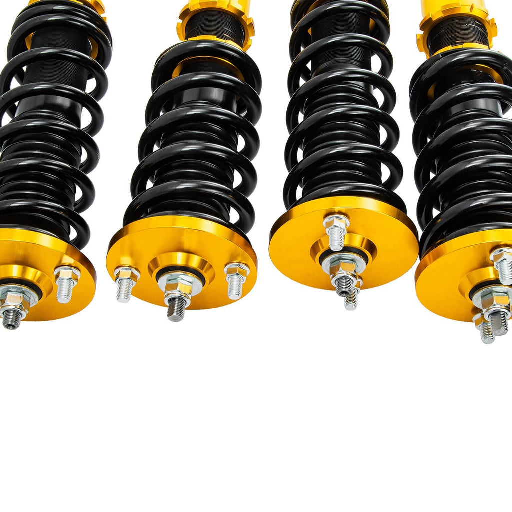 Close-up of coilover springs with adjustable gold top mounts and yellow shock bodies