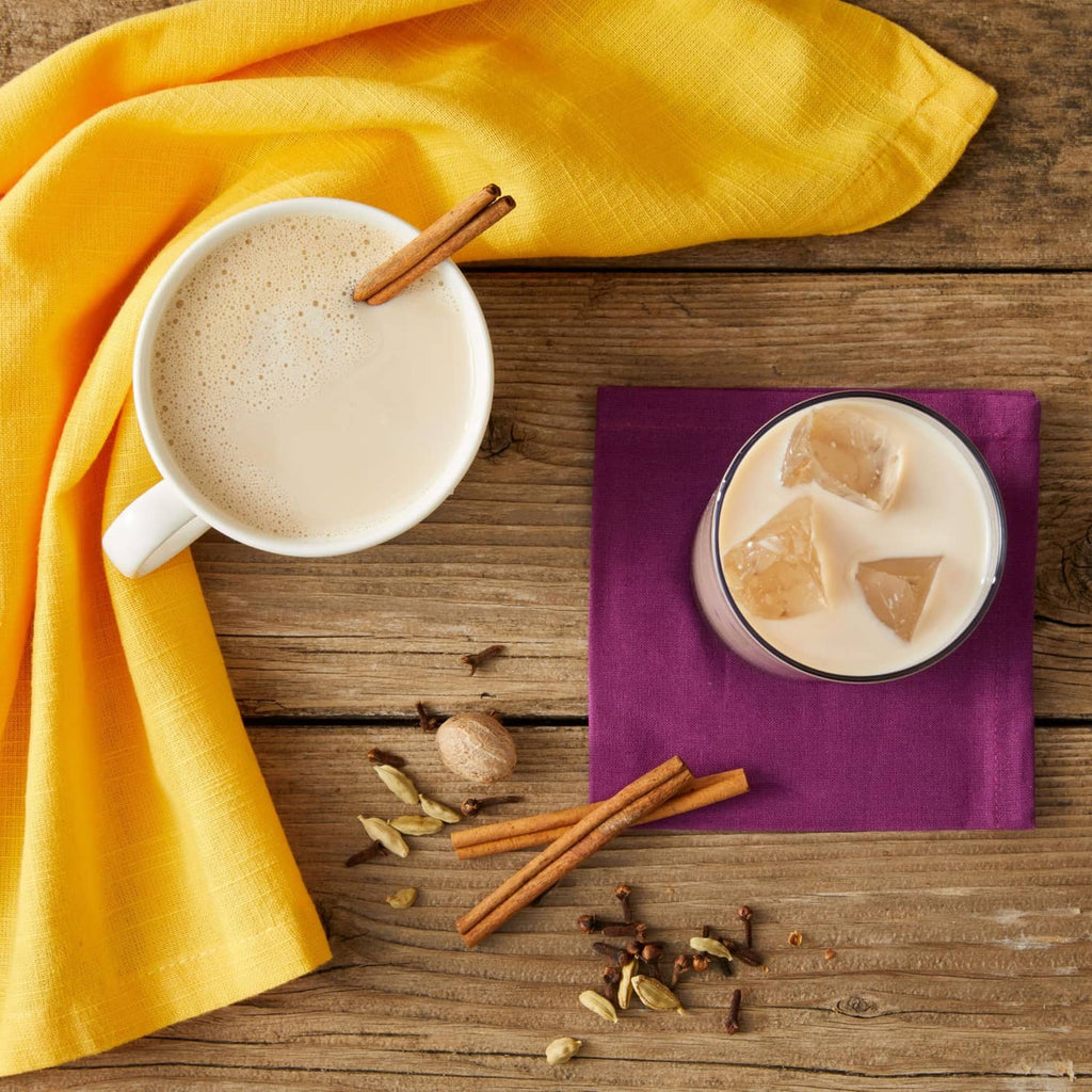 Chai latte made with Oregon Chai mix in cup and glass with cinnamon sticks