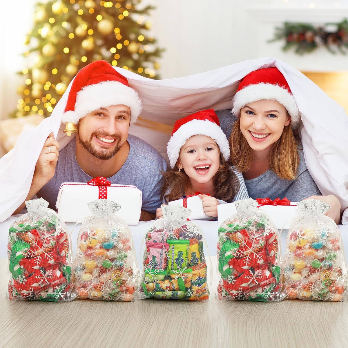 Transparent organza drawstring gift bags with treats inside on a holiday table