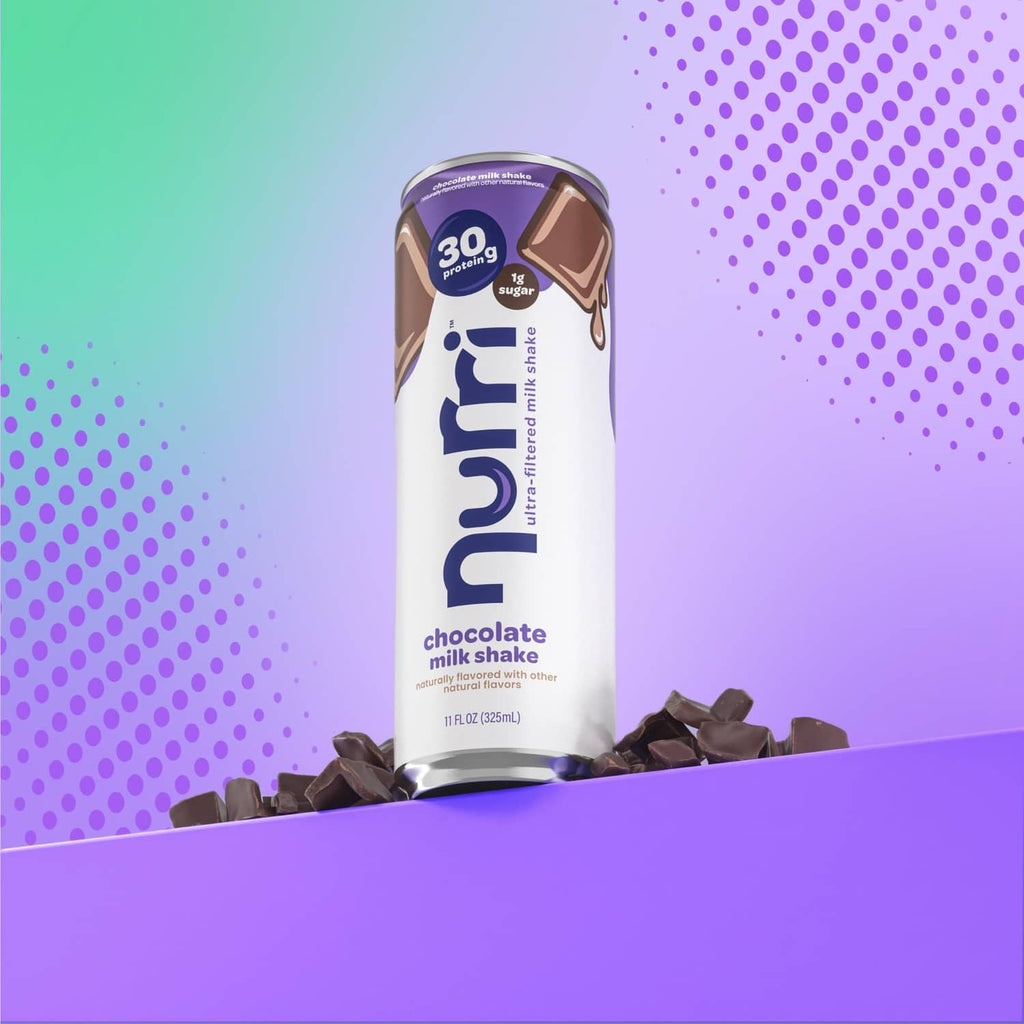 Chocolate milk shake can with chocolate pieces beside it