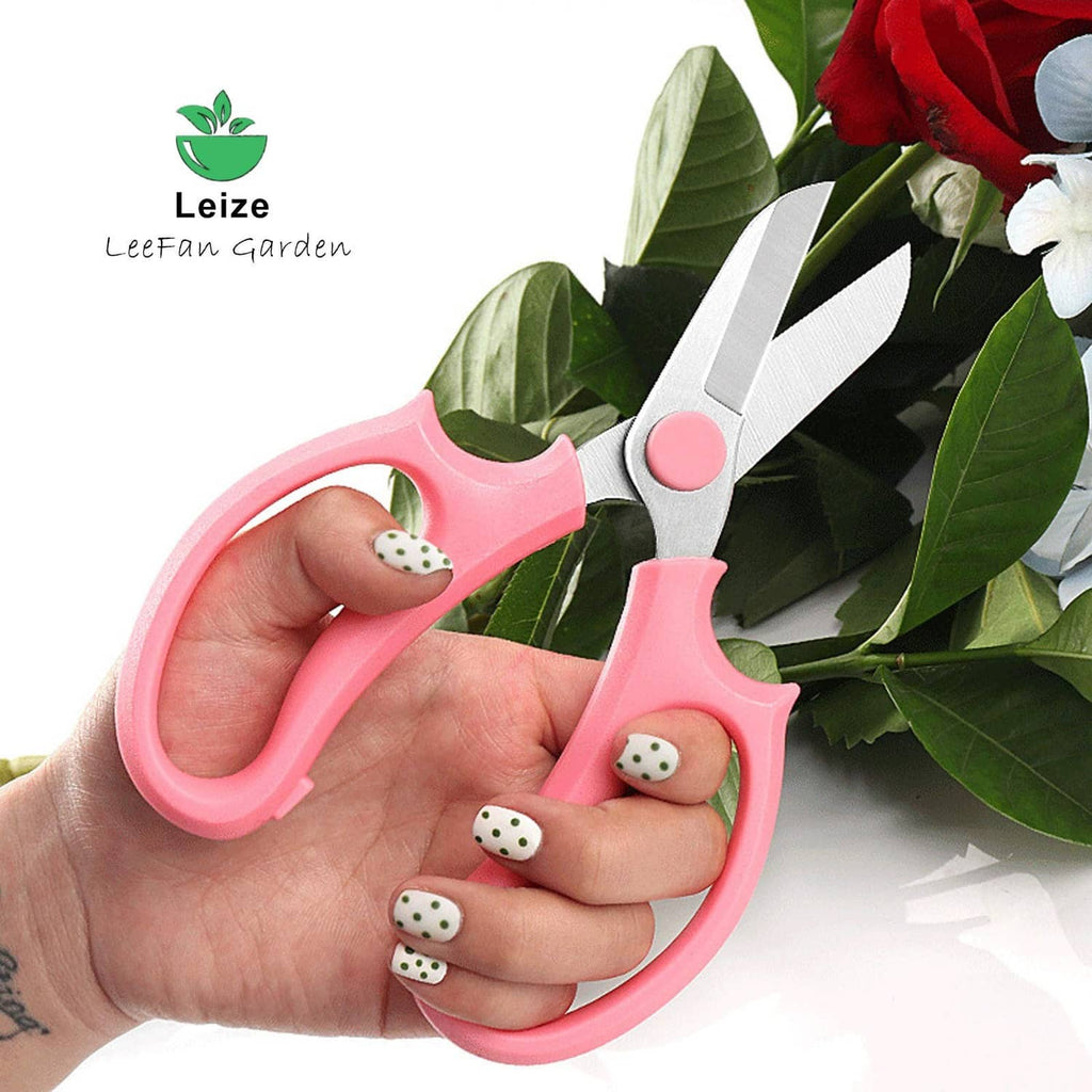 Pink flower scissors held in hand with two stainless steel blades