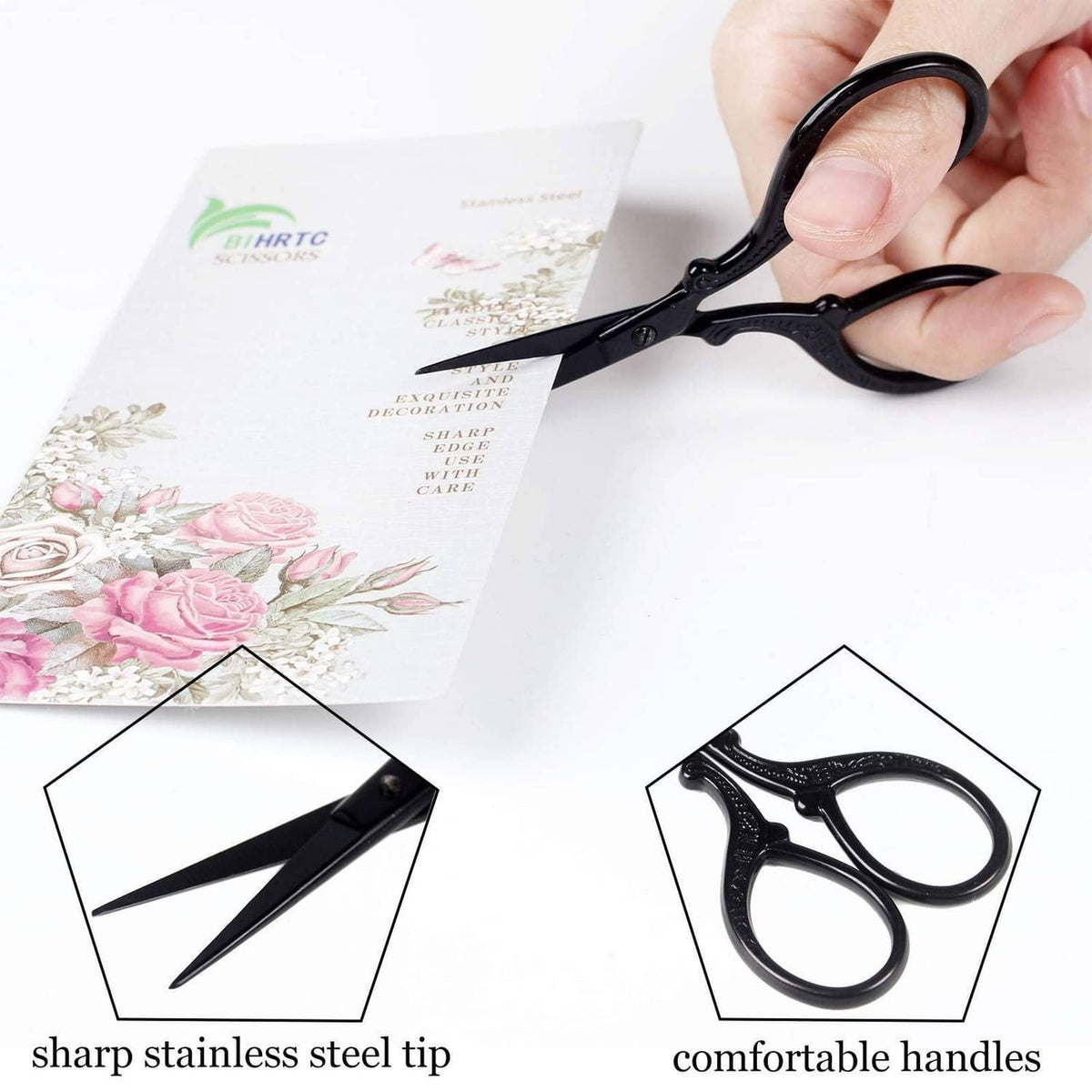 Black embroidery scissors held by hand with pointed stainless steel blades