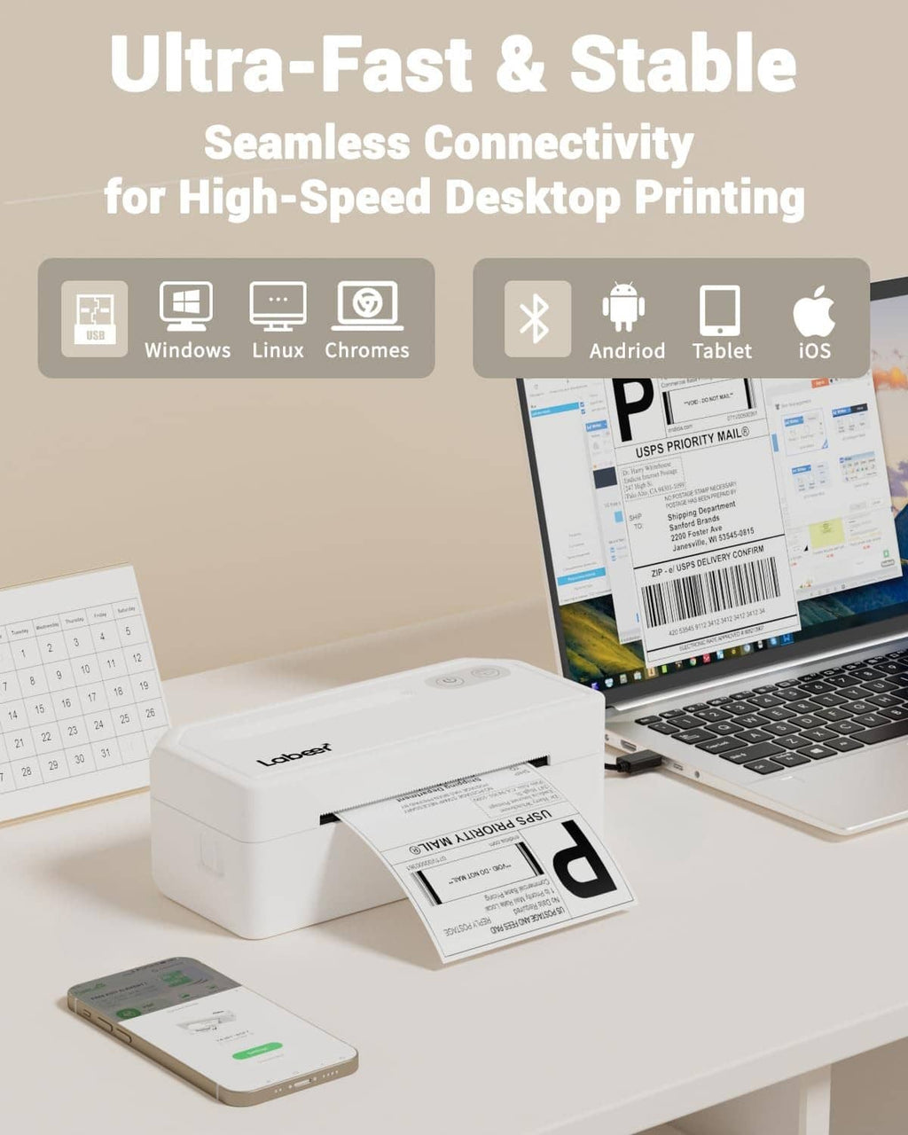White 4x6 wireless thermal label printer on desk beside smartphone and laptop