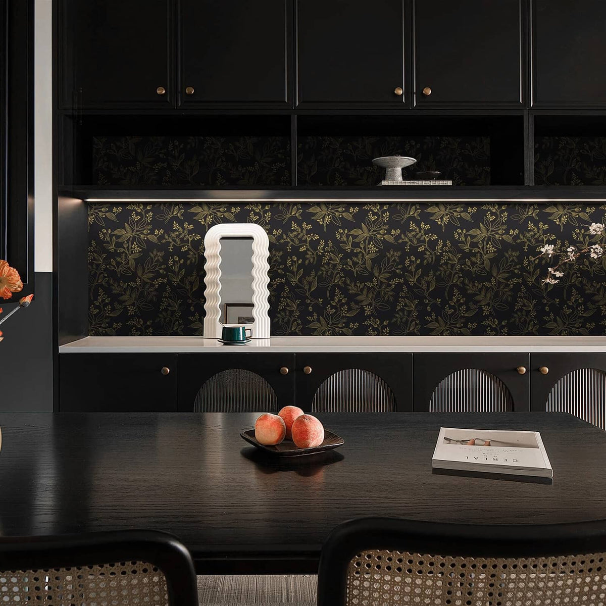 Black and gold botanical wallpaper panel behind open shelving with cabinet doors