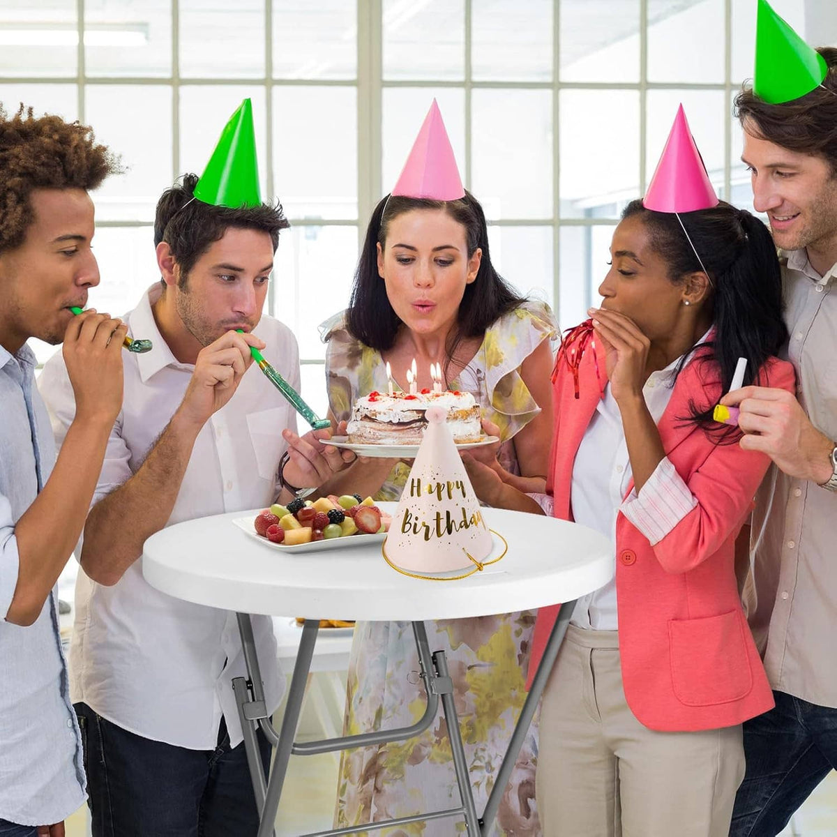 White round folding cocktail table holding a birthday cake with party hats
