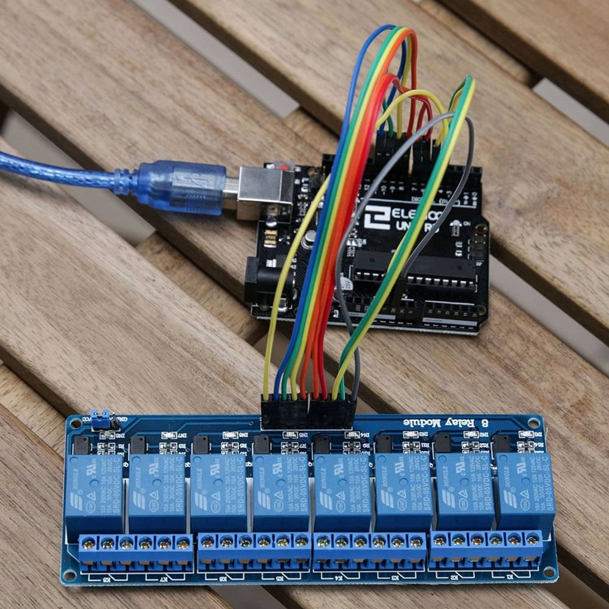 8-channel DC relay module with optocouplers connected with colorful wires on a board