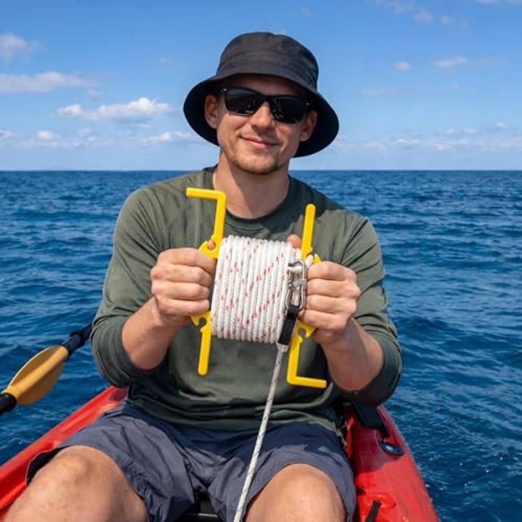 Person holding large anchor rope winder with yellow handles and wrapped white rope coil.