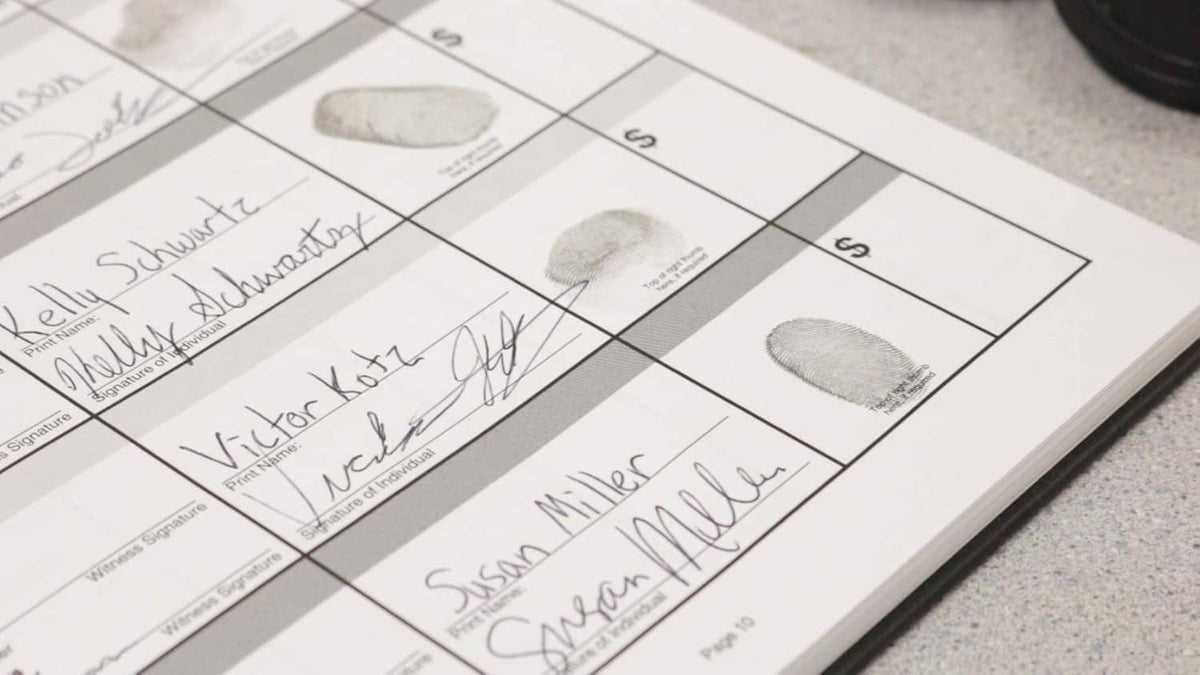 Close-up of fingerprint impressions on a worksheet, inkless pad nearby