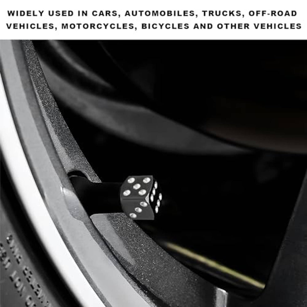 Small black dice-style valve stem cap with silver dots on a vehicle tire valve