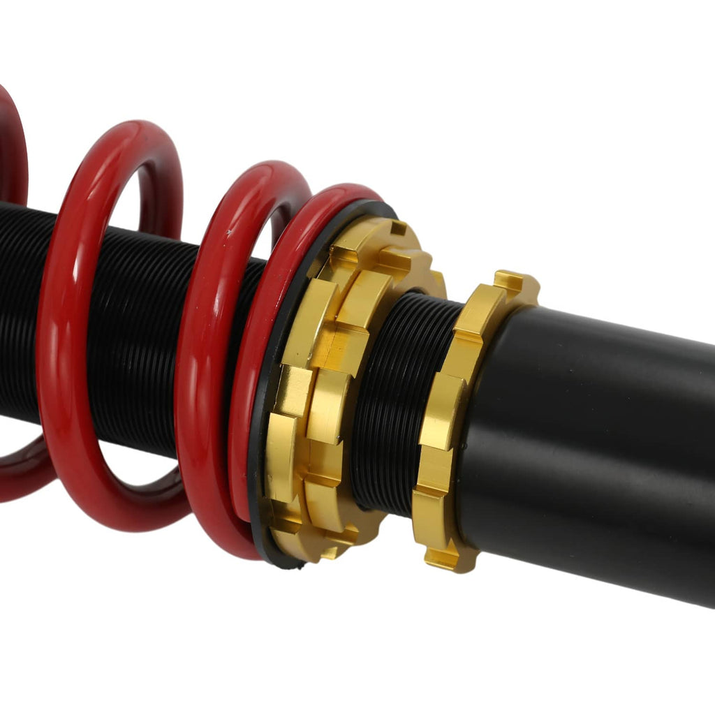 Gold adjustment collars on black coilover strut with red spring