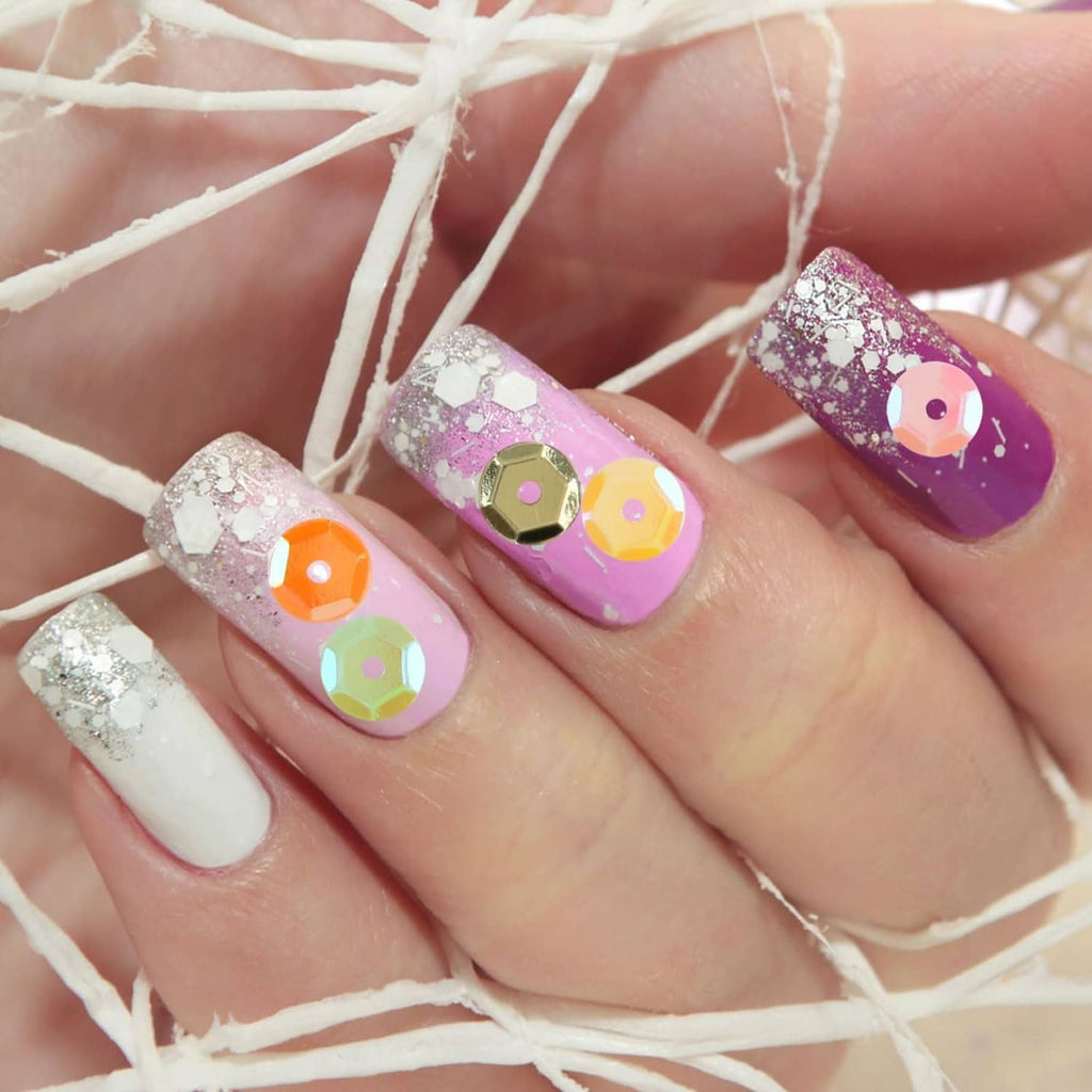 Nail art with small iridescent sequins in silver and purple on manicure tips