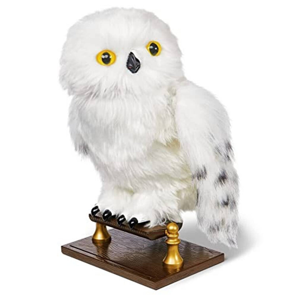 White fluffy owl plush on a dark brown stand with gold posts and amber eyes.