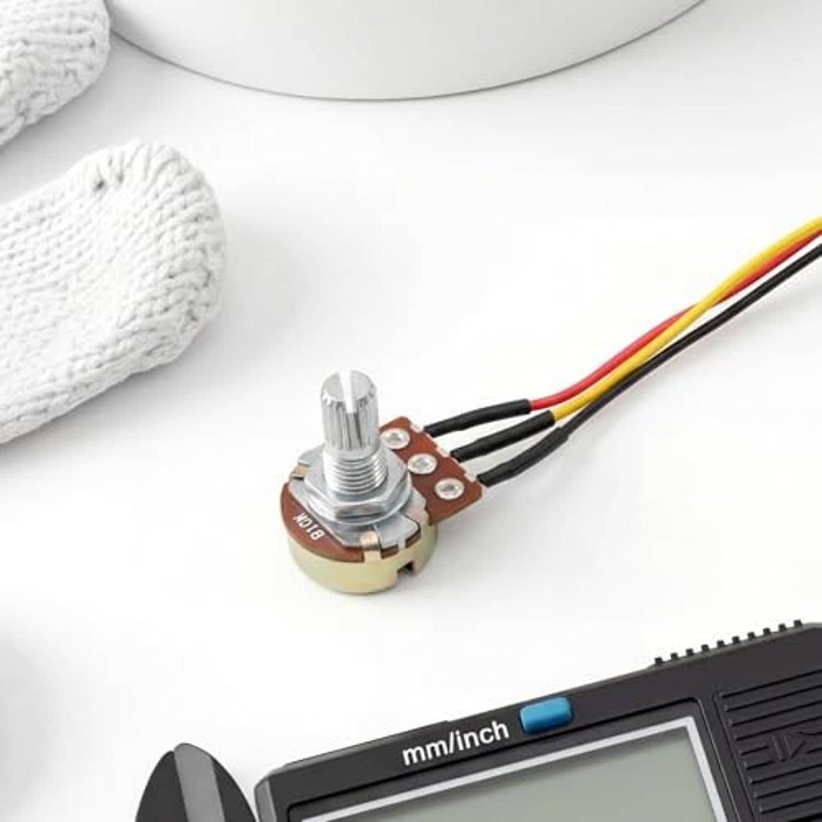 Rotary potentiometer with blue knob and silver knurled shaft with multicolor leads