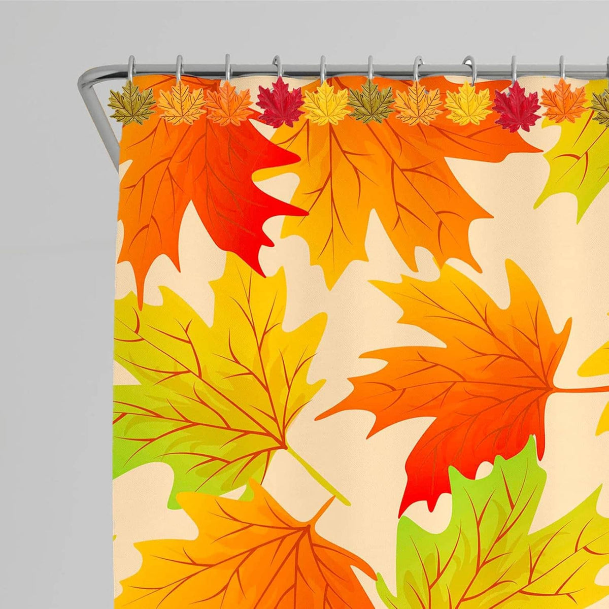 Close-up of leaf shower curtain hooks on an orange patterned curtain; chrome metal rings