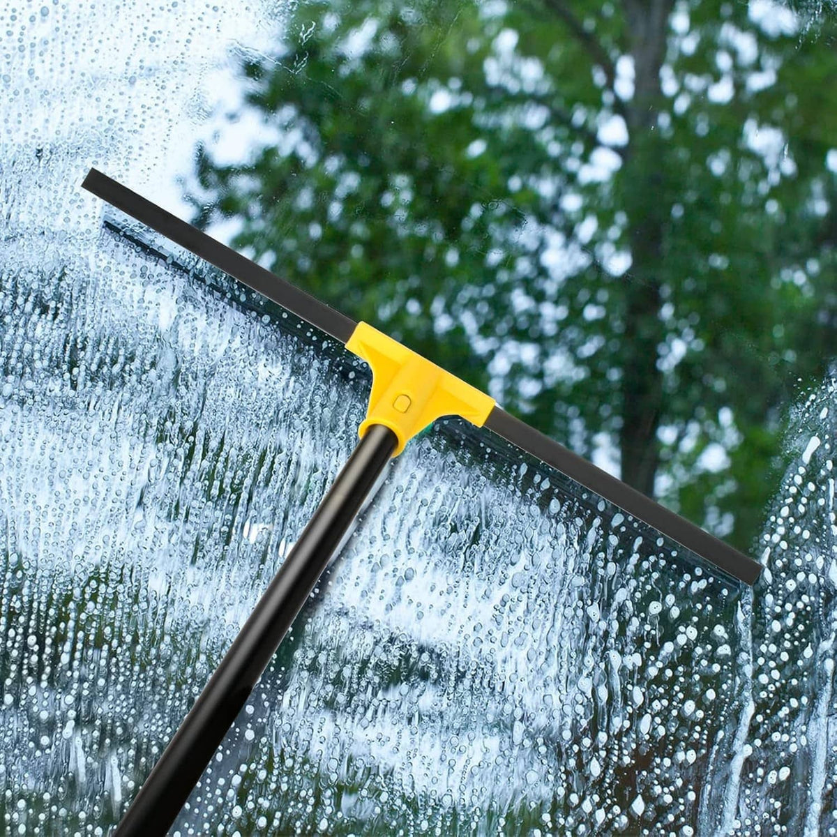 Yellow and black floor squeegee blade removing water from a wet surface