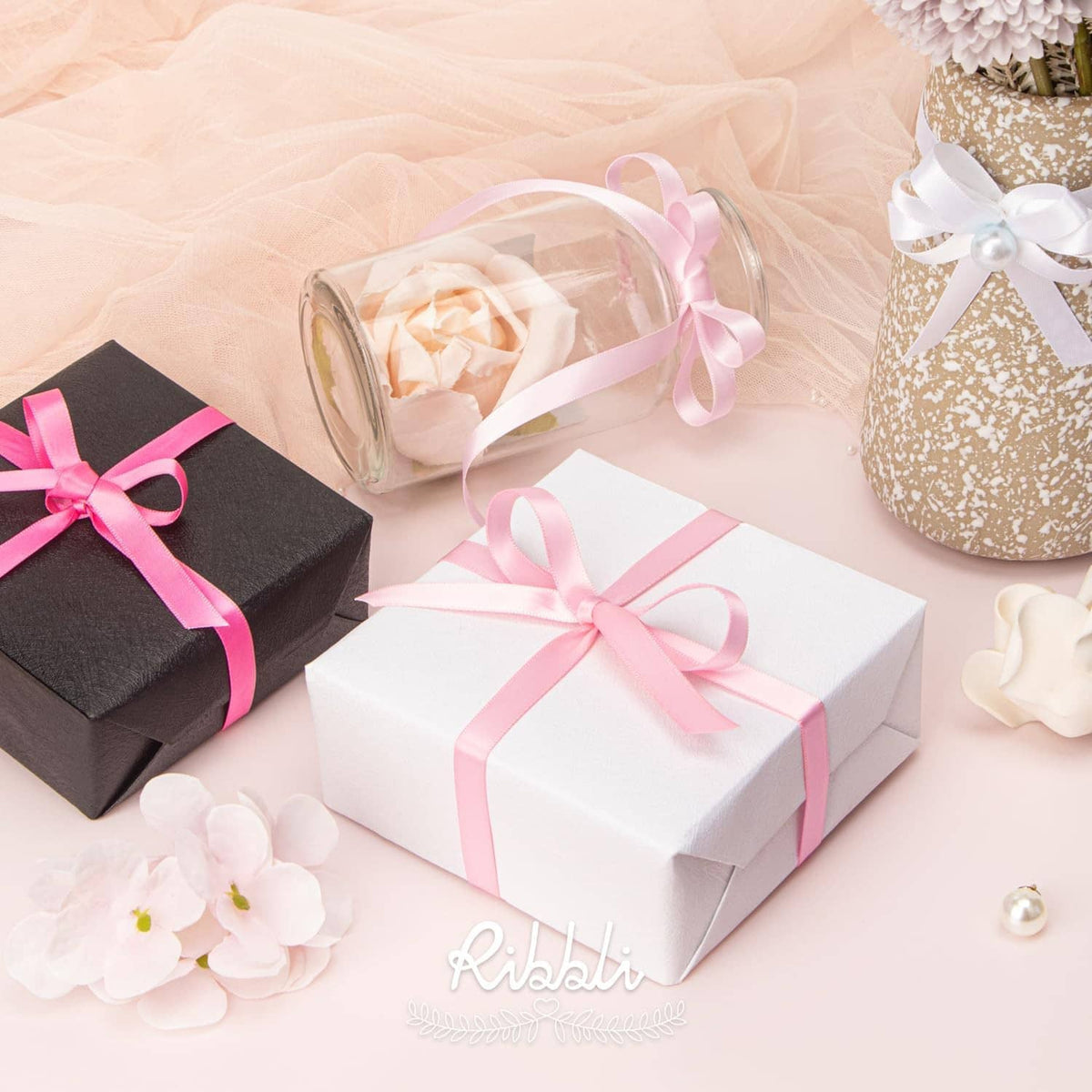 Pink satin ribbon rolls used to tie gift boxes