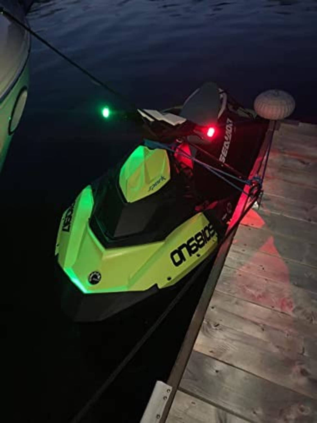 LED marine bow navigation lights on kayak deck, green and red glow near the front