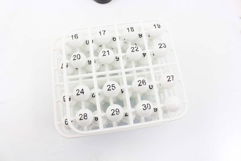 White bingo balls in a transparent bingo cage with numbered grid