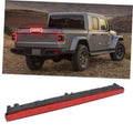 Third brake light bar with red lens and LED strip on a rear vehicle panel