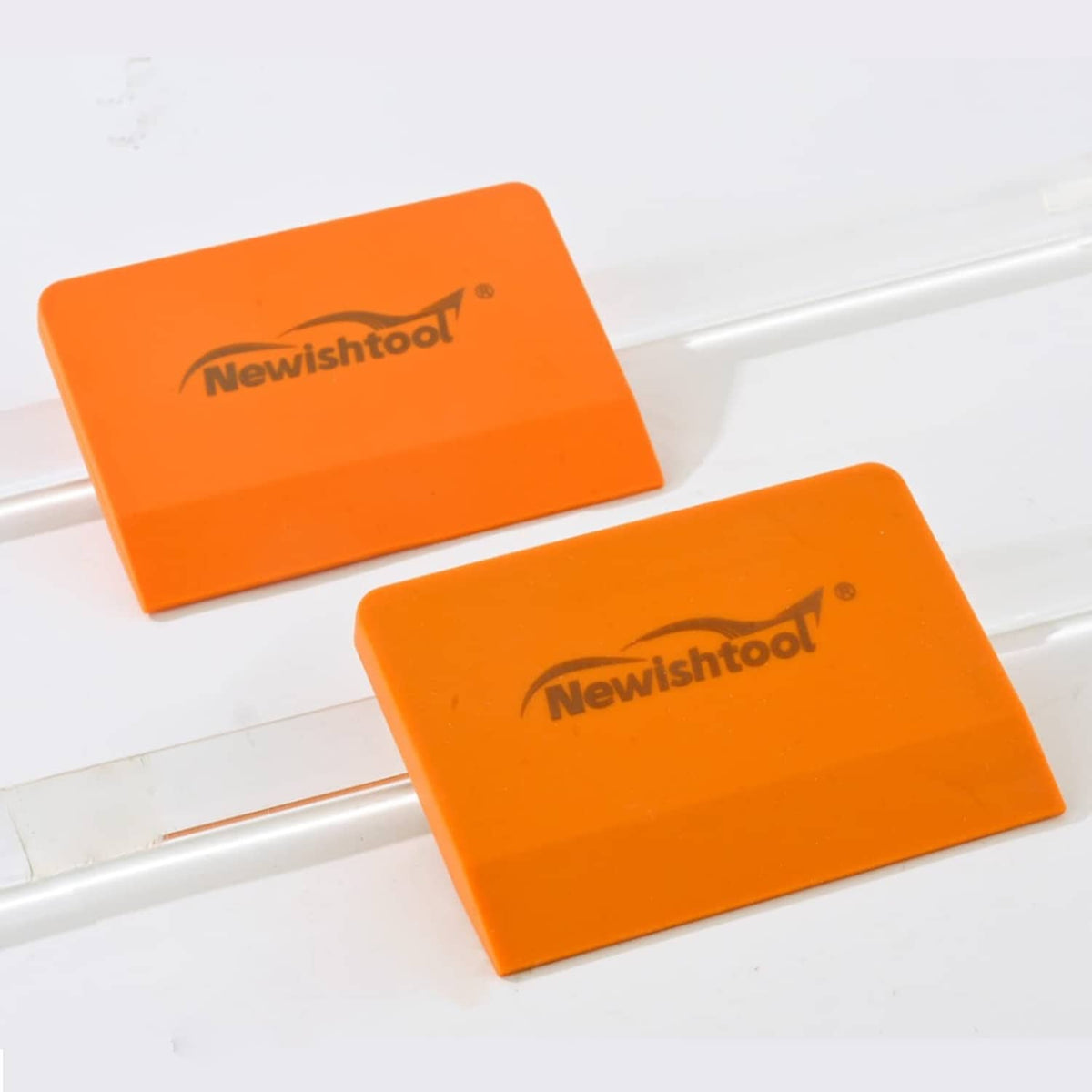 Orange Newishtool silicone squeegee pads, rectangular shape, set of 2 on surface.