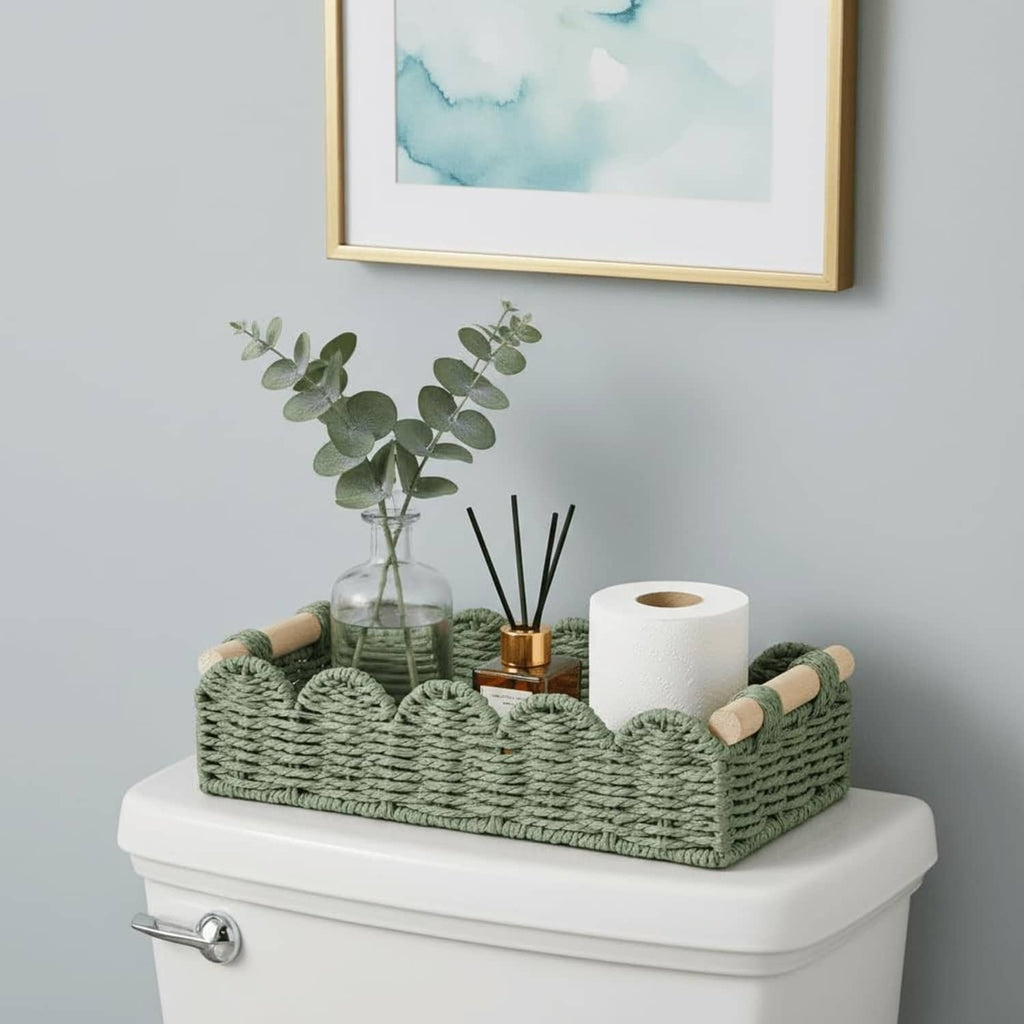 Green woven toilet paper storage basket with toilet paper roll and side loop handles