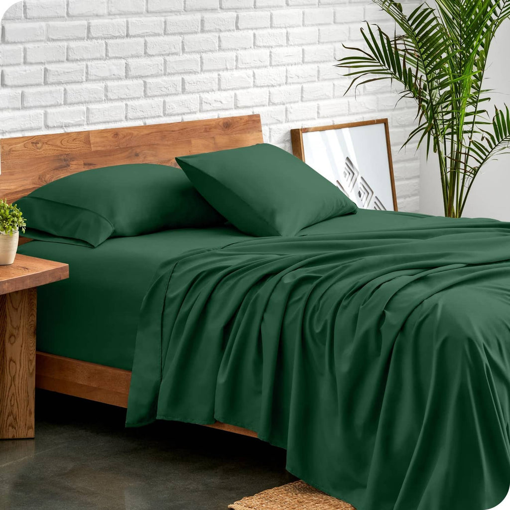Forest green twin bed sheet set with neatly folded corners and pillows