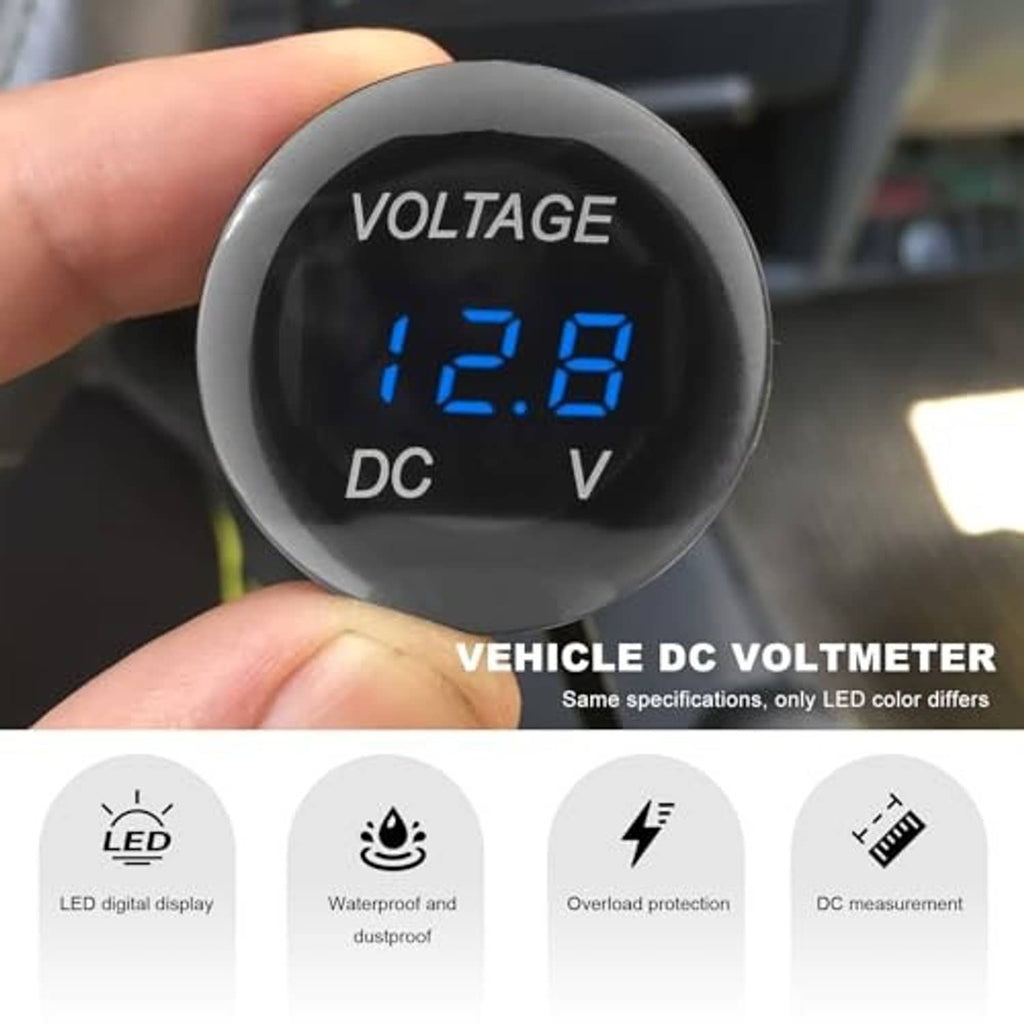 Hand holding black DC voltmeter gauge showing blue 12.8 LED digits and V