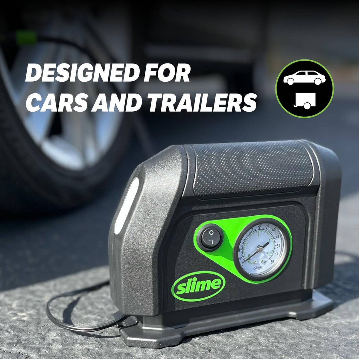 12V portable tire inflator with analog gauge and air hose, shown on the ground