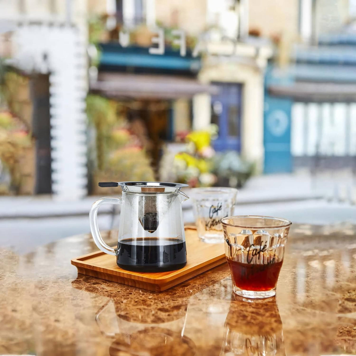Stainless steel pour-over coffee dripper on glass carafe with black handle