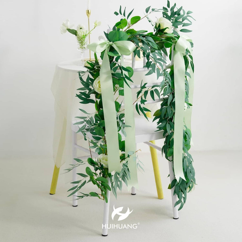 Seafoam green satin ribbon bow with hanging ribbon tails over a chair decoration.