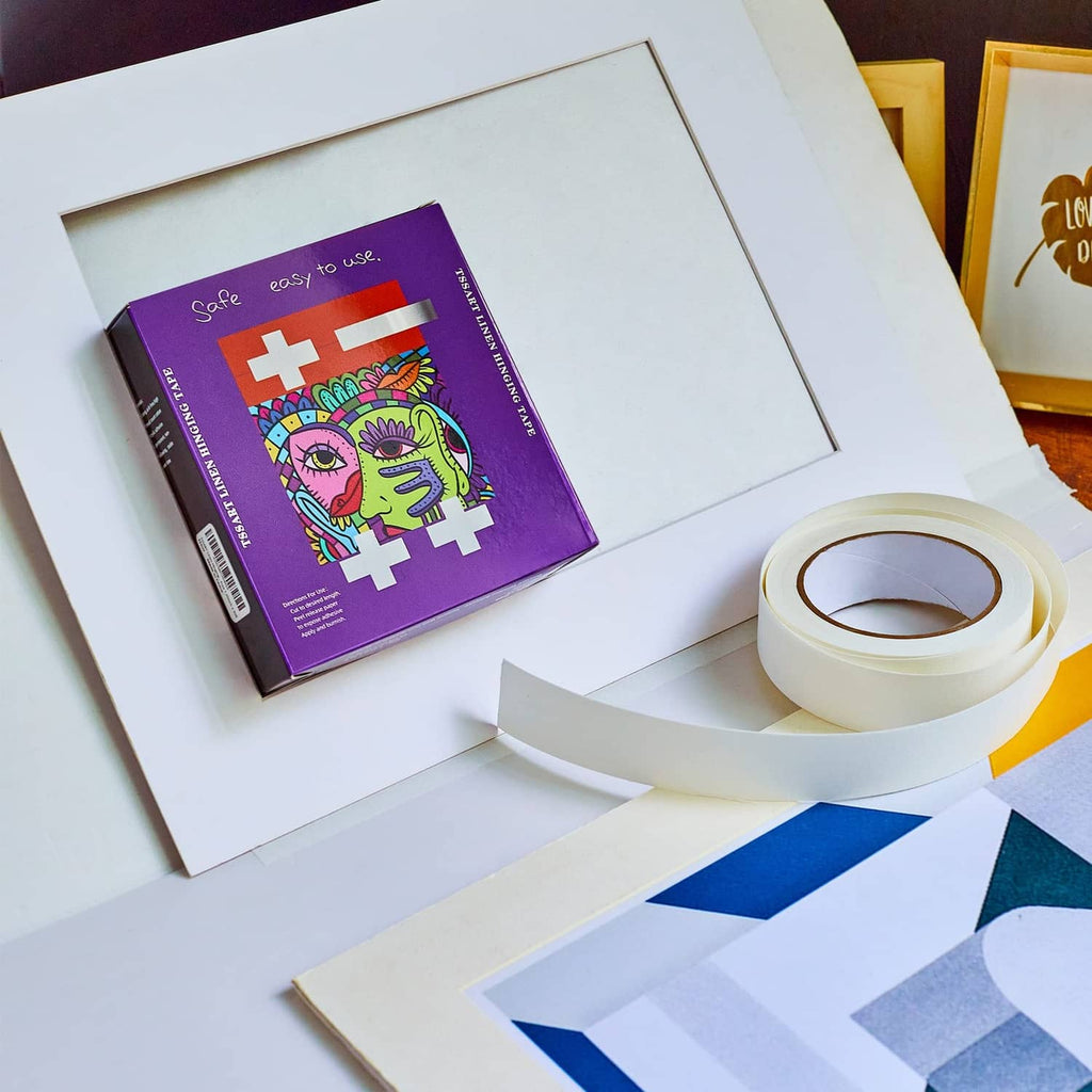 Self-adhesive tape roll and strips next to mounted poster board