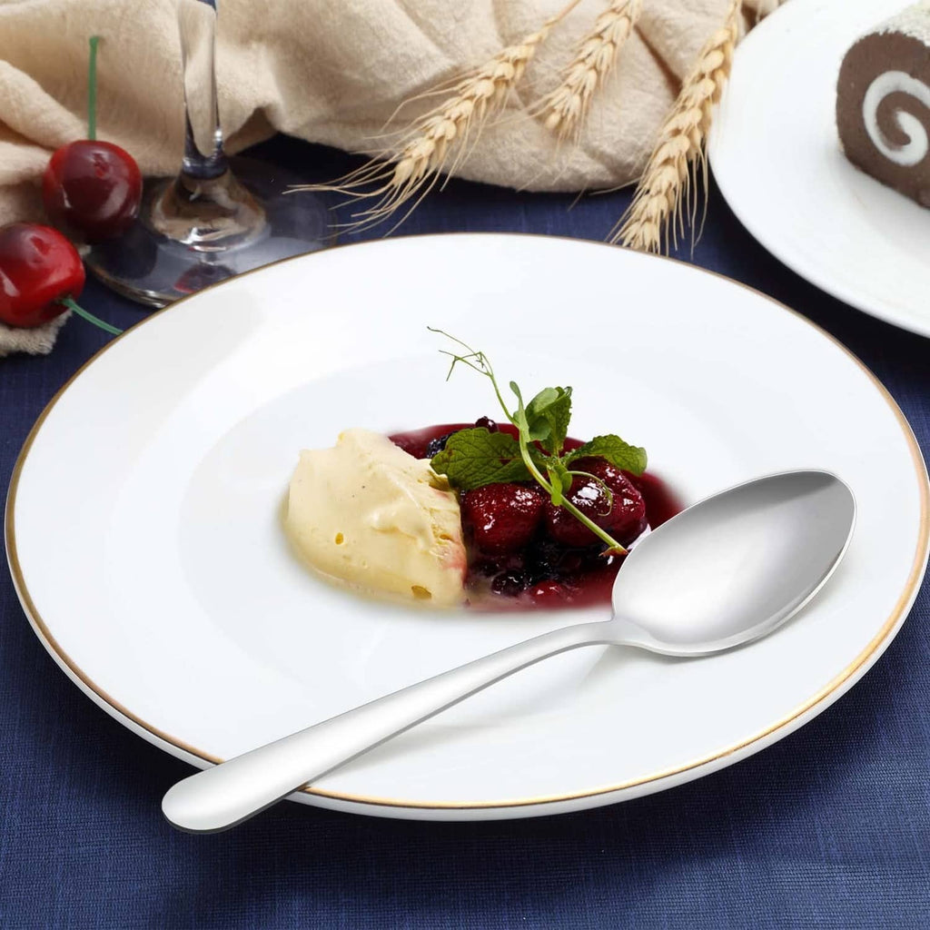 Funnydin stainless dinner spoon, polished silver, spoon resting on a plate with food