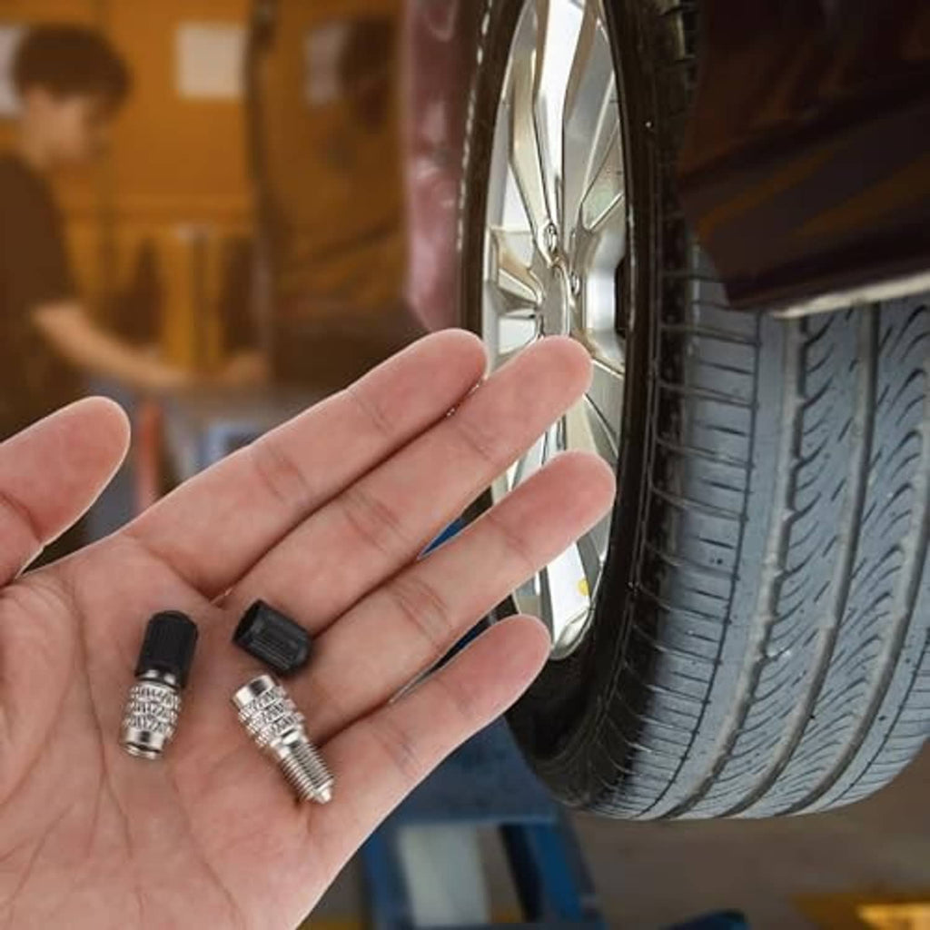 Valve stem extension caps held in hand: black ribbed tops and metal threads