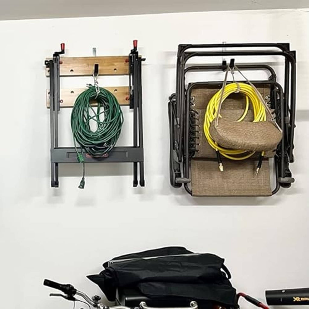 Black garage wall hooks holding coiled cords and a tool attachment