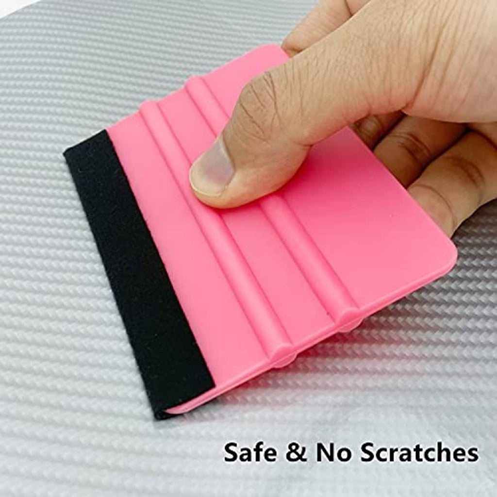 Pink vinyl squeegee tool with black felt pad smoothing film on textured surface
