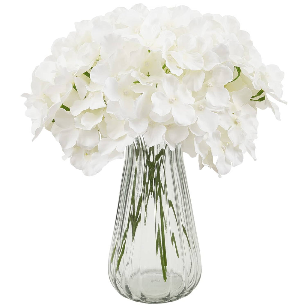 White artificial hydrangea bouquet with layered petals in glass vase, close view