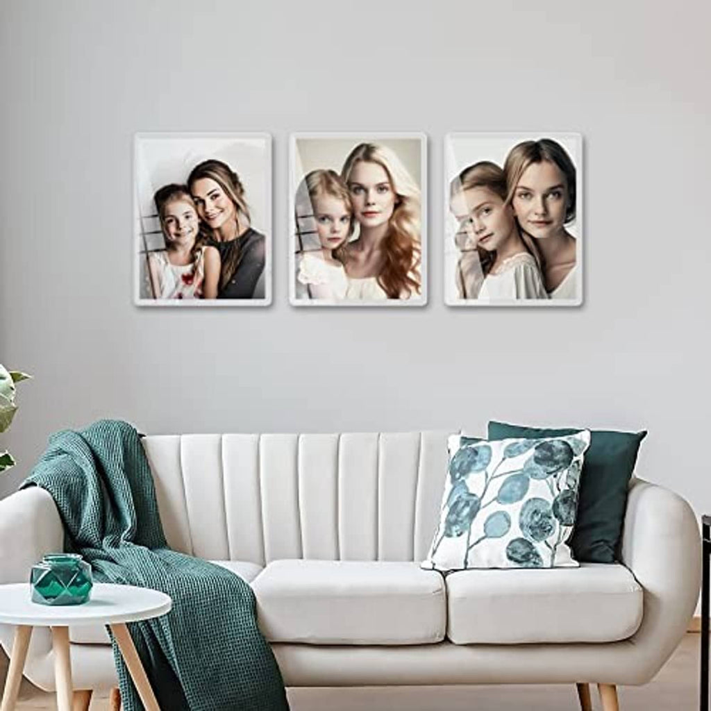 White 8x10 picture frames set on wall displaying small portrait photos.