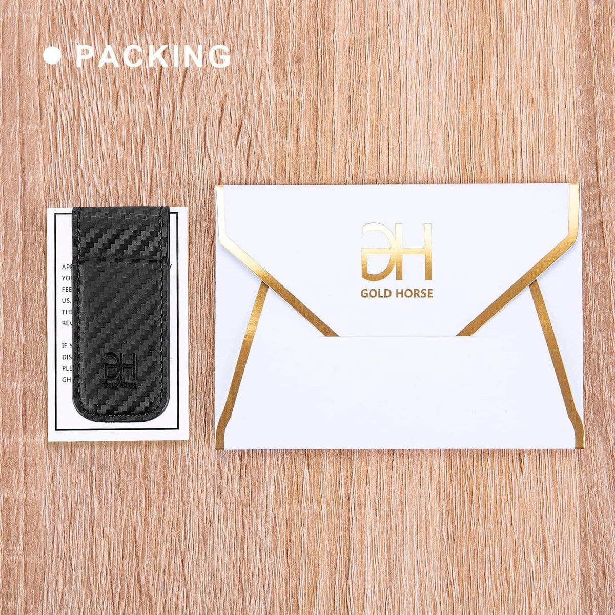 Black carbon-fiber money clip card holder shown with packaging envelope and logo card