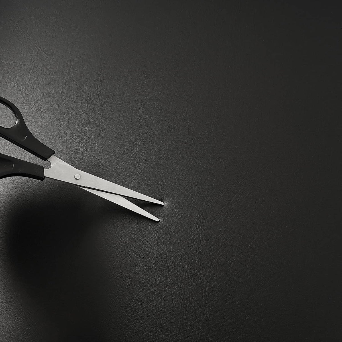 Metal scissors and hand tools near black cushion material