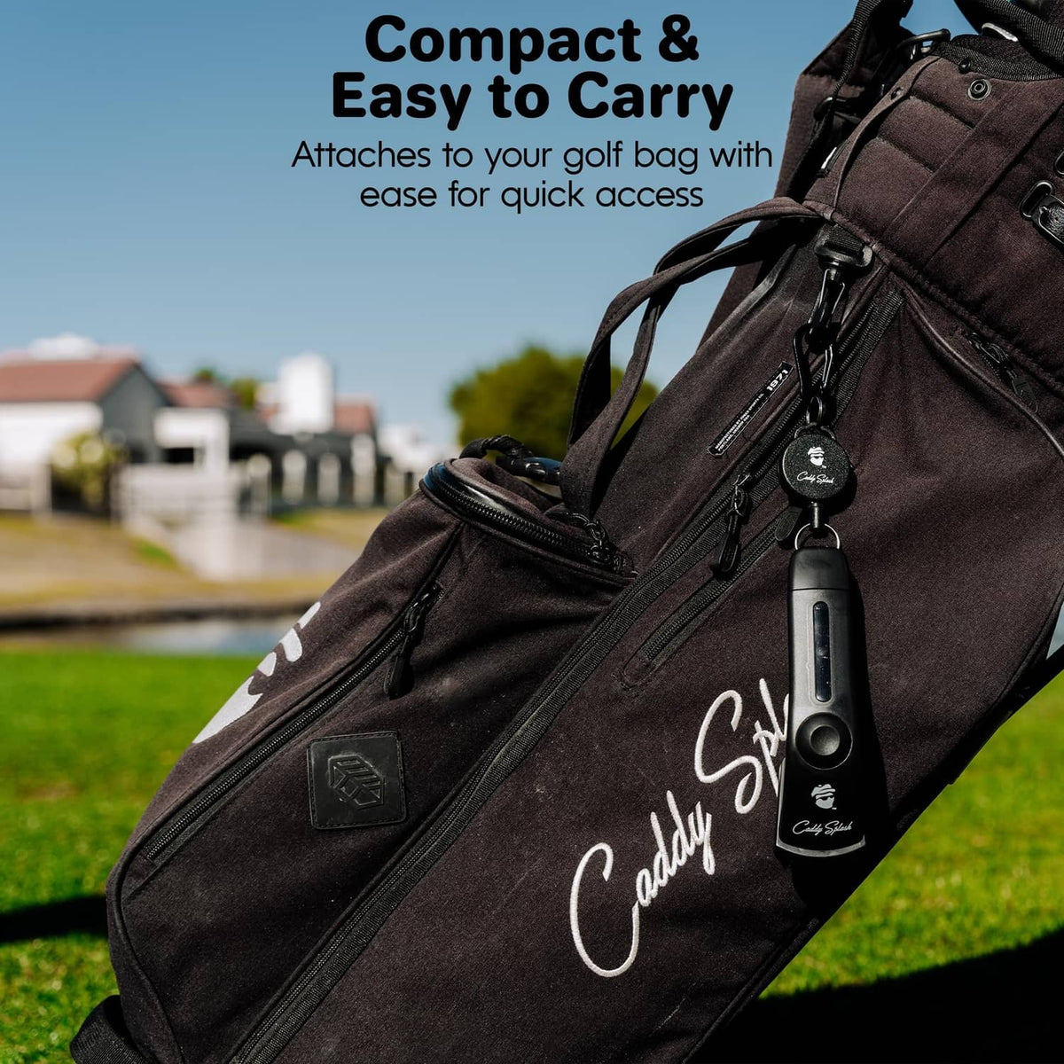 Black golf club brush cleaner clipped to the side of a golf bag